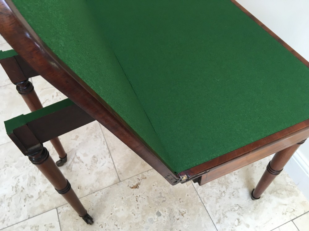 A Regency mahogany fold-over card table featuring turned tapered legs, brass castors, and boxwood stringing inlay along the frieze. View XIV