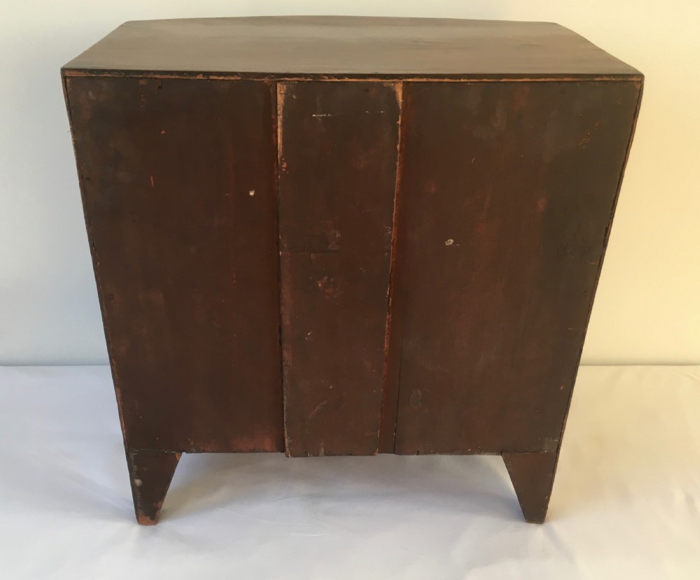A miniature mahogany bow-fronted chest of drawers featuring turned wooden knobs and a polished grain finish. View IX