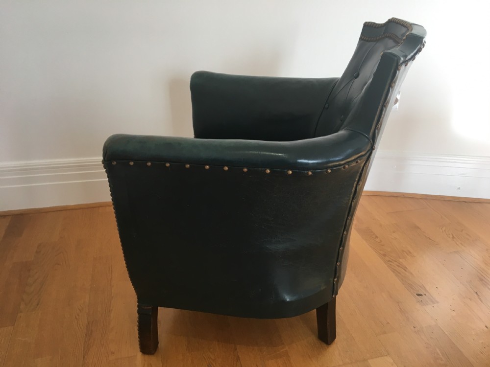 An Edwardian dark green leather library armchair featuring deep button tufting, brass stud trim, and dark timber legs. View XIII