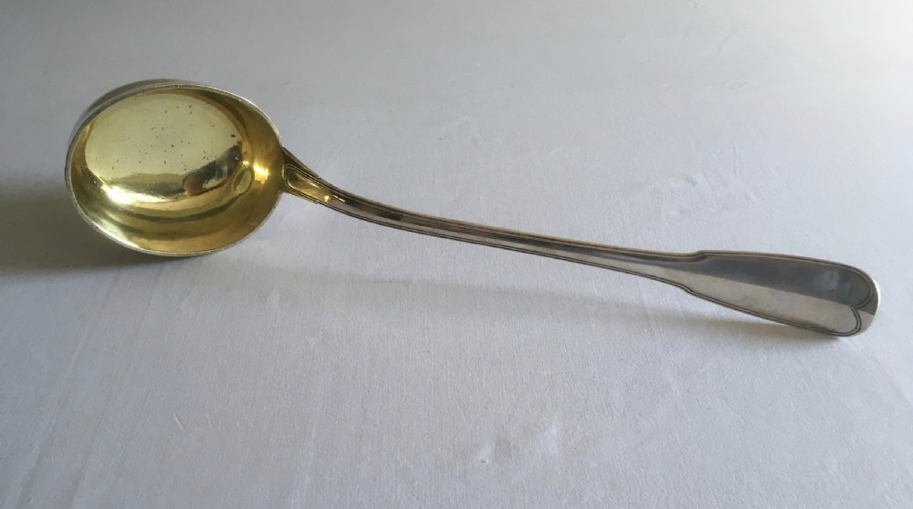 An antique silver soup or punch ladle featuring a deep gilt-washed bowl and a contoured handle. View V