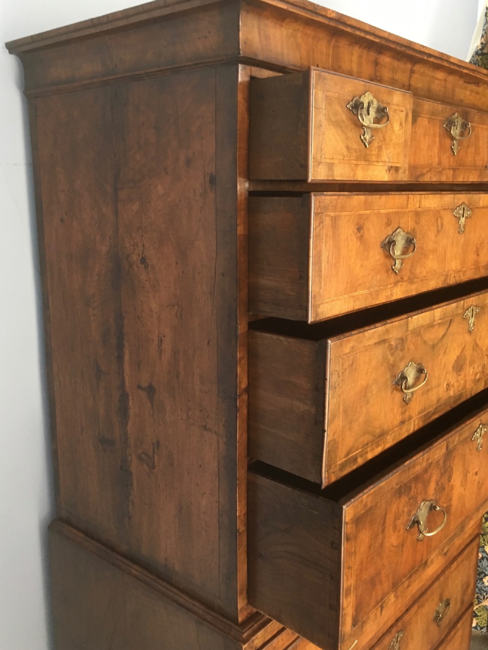 An 18th-century George II walnut tallboy chest-on-chest featuring figured veneer drawers, brass drop handles, and bracket feet. View IV