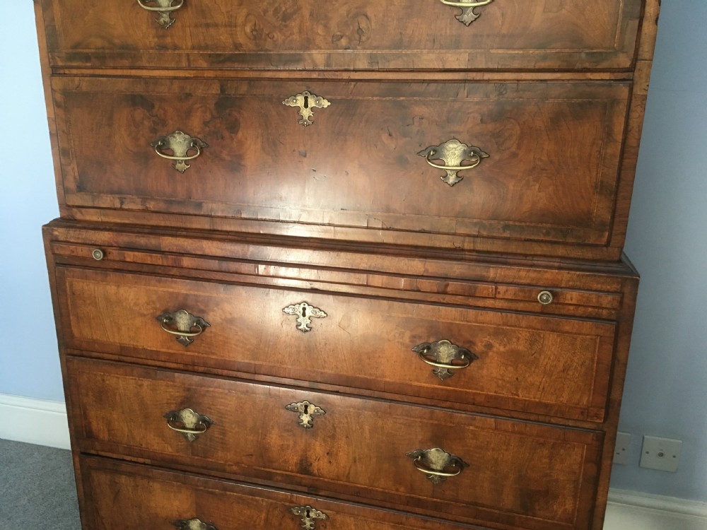 An 18th-century George II walnut tallboy chest-on-chest featuring figured veneer drawers, brass drop handles, and bracket feet. View VI