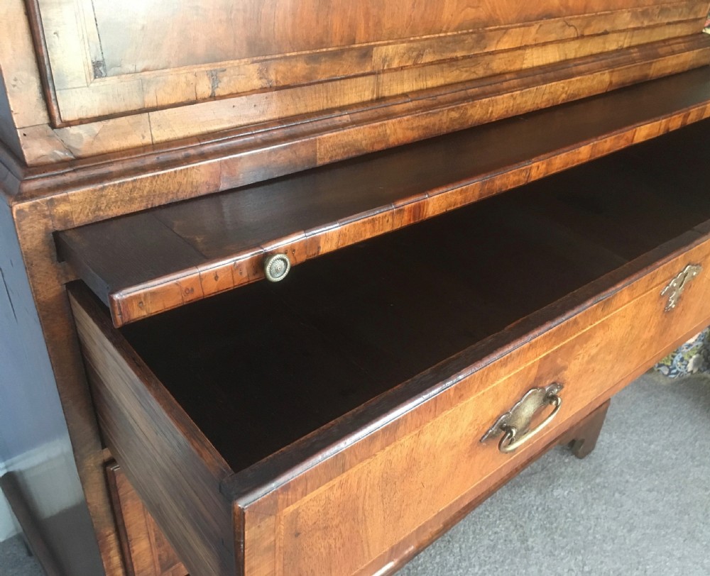 An 18th-century George II walnut tallboy chest-on-chest featuring figured veneer drawers, brass drop handles, and bracket feet. View VII