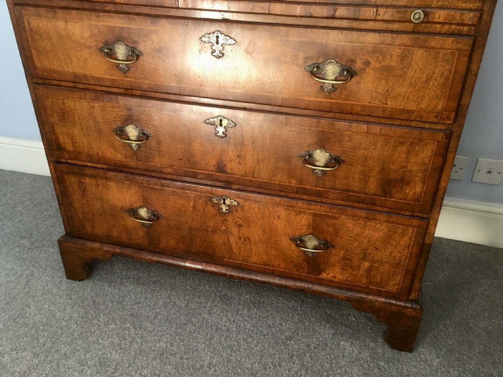 An 18th-century George II walnut tallboy chest-on-chest featuring figured veneer drawers, brass drop handles, and bracket feet. View IX