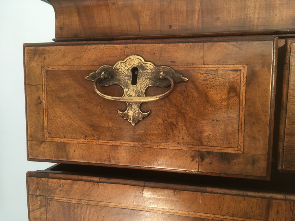 An 18th-century George II walnut tallboy chest-on-chest featuring figured veneer drawers, brass drop handles, and bracket feet. View X