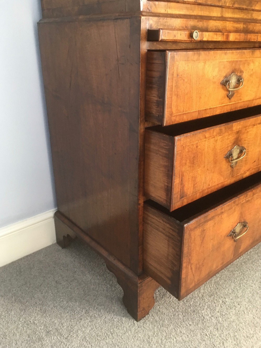 An 18th-century George II walnut tallboy chest-on-chest featuring figured veneer drawers, brass drop handles, and bracket feet. View XII