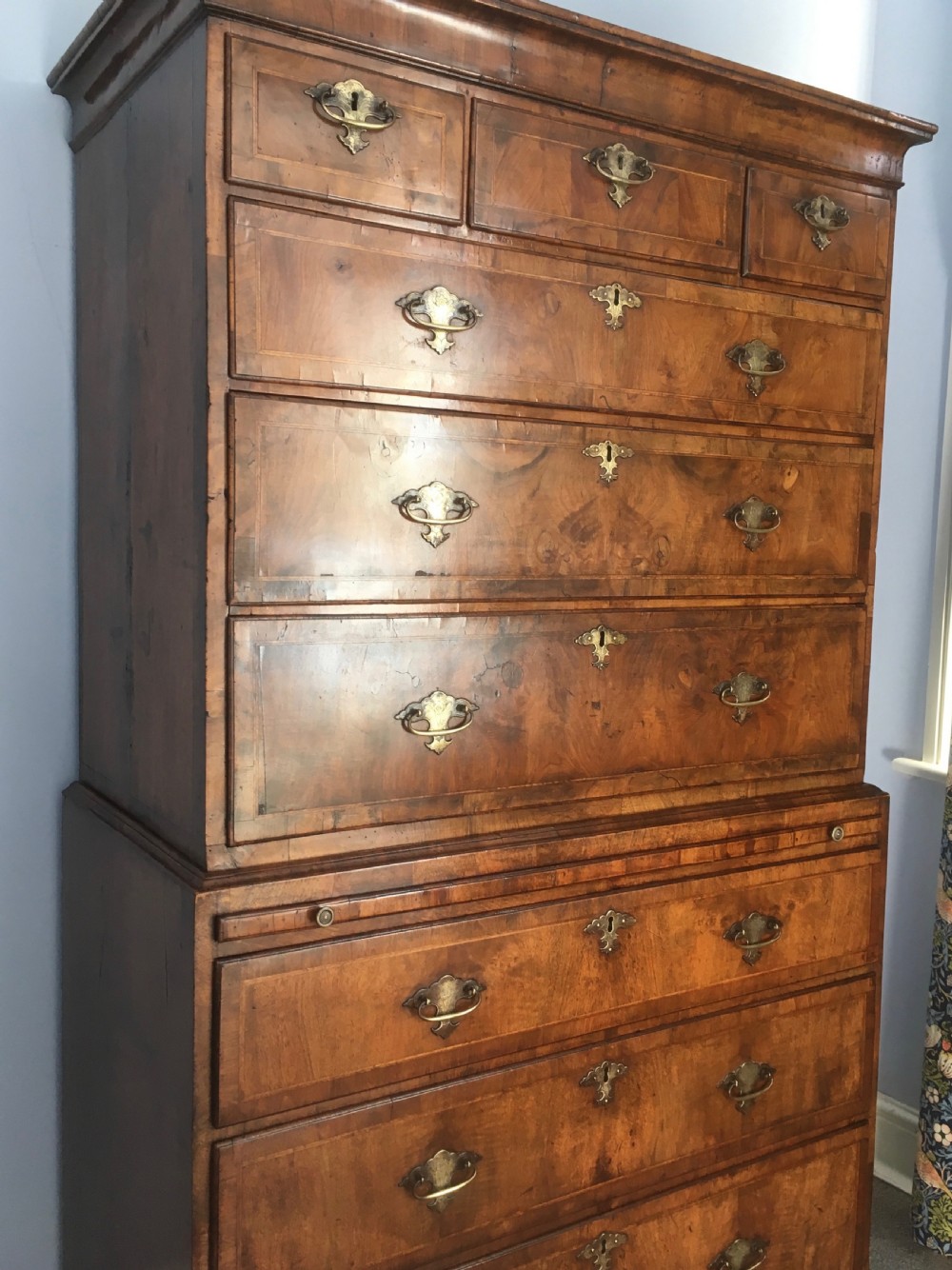 An 18th-century George II walnut tallboy chest-on-chest featuring figured veneer drawers, brass drop handles, and bracket feet. View XIV