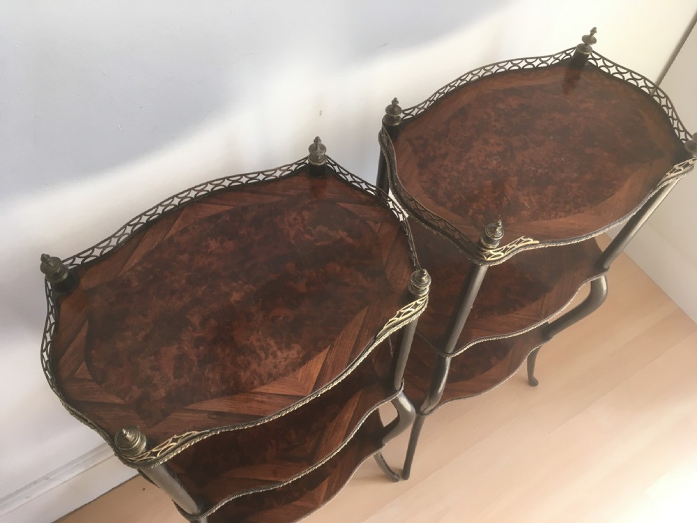 A pair of three-tiered French style side tables crafted from dark wood with inlaid marquetry work, gilt metal gallery rails, and cabriole legs. View IV