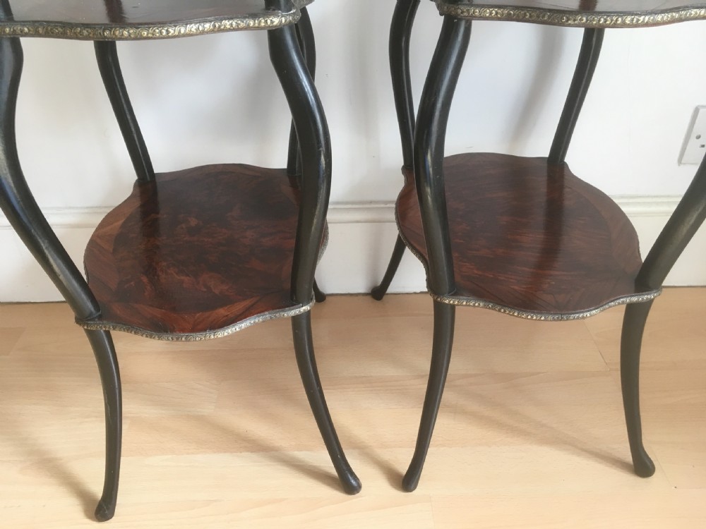 A pair of three-tiered French style side tables crafted from dark wood with inlaid marquetry work, gilt metal gallery rails, and cabriole legs. View IX