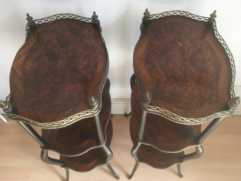 A pair of three-tiered French style side tables crafted from dark wood with inlaid marquetry work, gilt metal gallery rails, and cabriole legs. View XI
