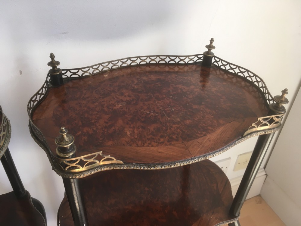 A pair of three-tiered French style side tables crafted from dark wood with inlaid marquetry work, gilt metal gallery rails, and cabriole legs. View XII