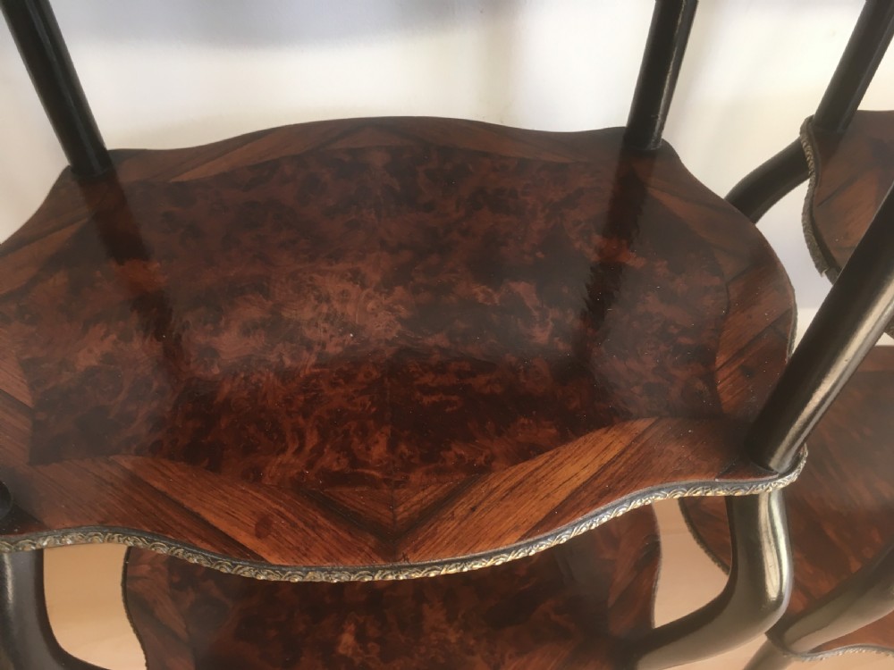A pair of three-tiered French style side tables crafted from dark wood with inlaid marquetry work, gilt metal gallery rails, and cabriole legs. View XIV