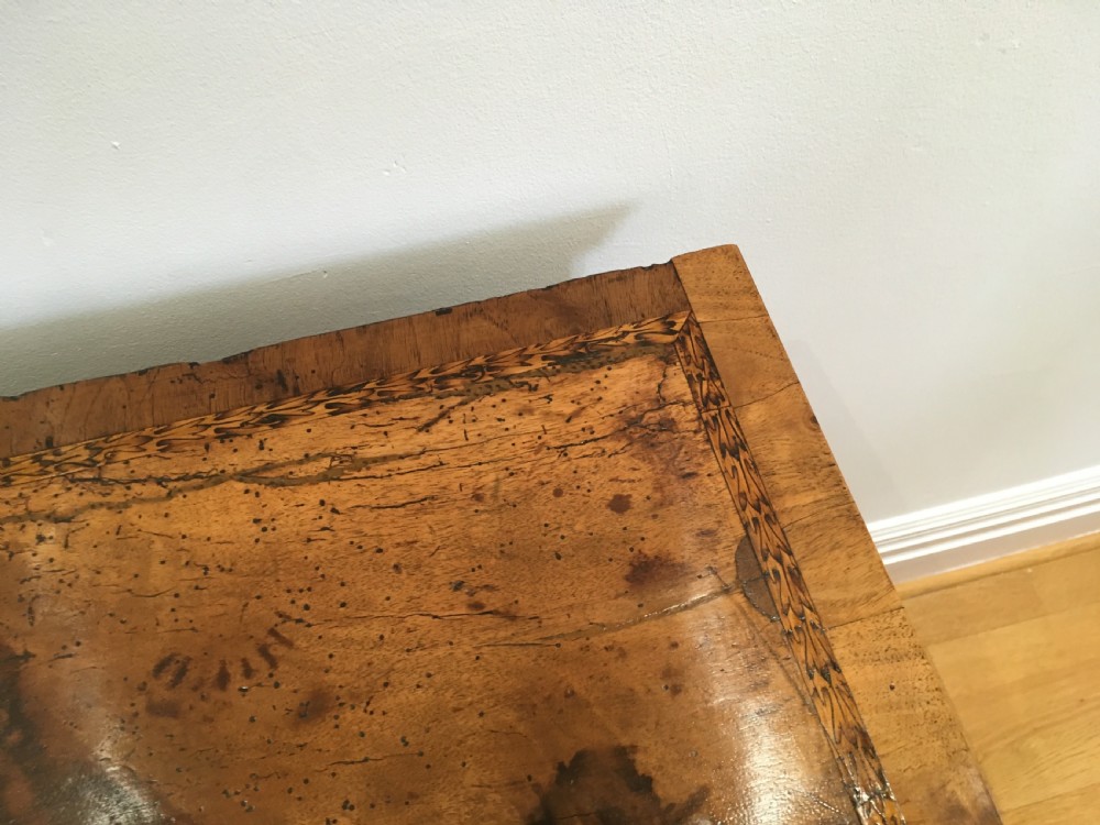 An eighteenth-century walnut chest of drawers featuring decorative poker work inlay, brass swing handles, keyhole escutcheons, and straight bracket feet. View VI