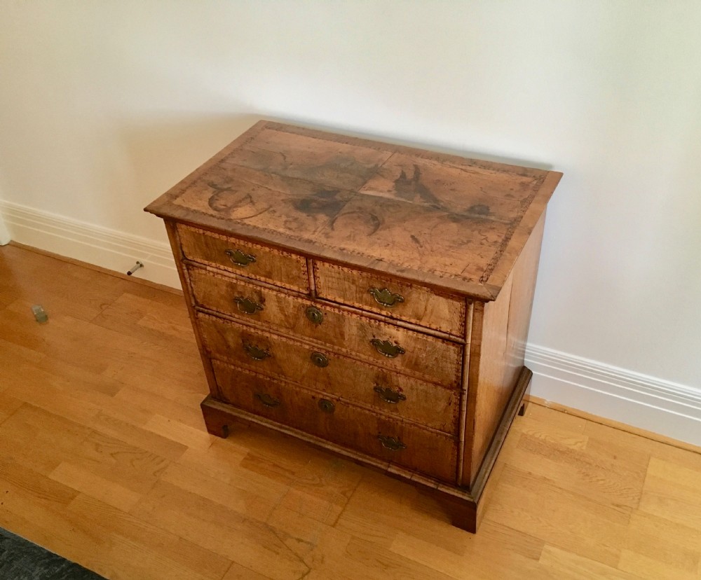 An eighteenth-century walnut chest of drawers featuring decorative poker work inlay, brass swing handles, keyhole escutcheons, and straight bracket feet. View VIII