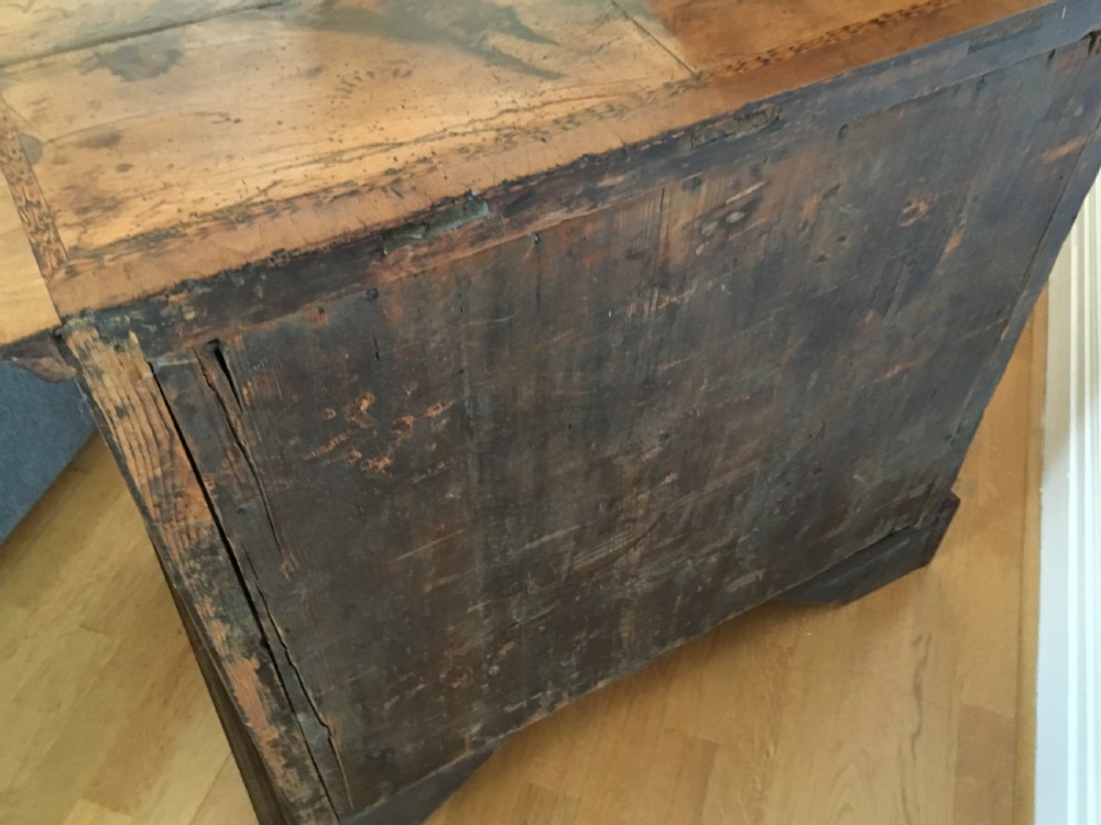 An eighteenth-century walnut chest of drawers featuring decorative poker work inlay, brass swing handles, keyhole escutcheons, and straight bracket feet. View XII