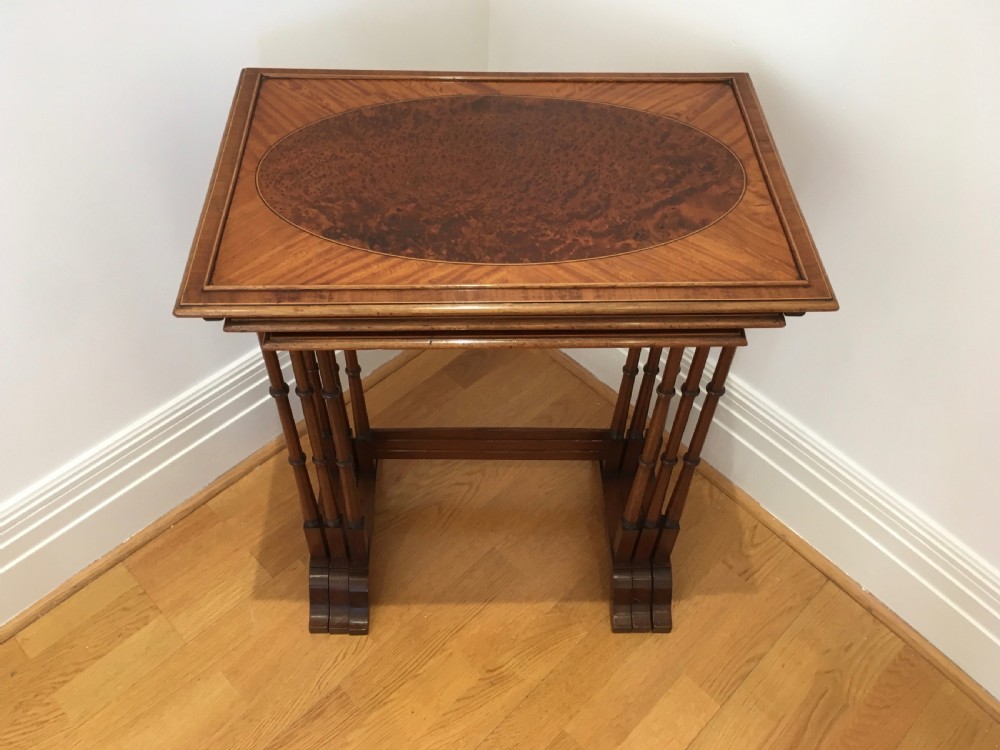 A set of three nested wooden side tables featuring rectangular tops with oval amboyna wood centres, inlaid satinwood borders, and slender turned legs. View II
