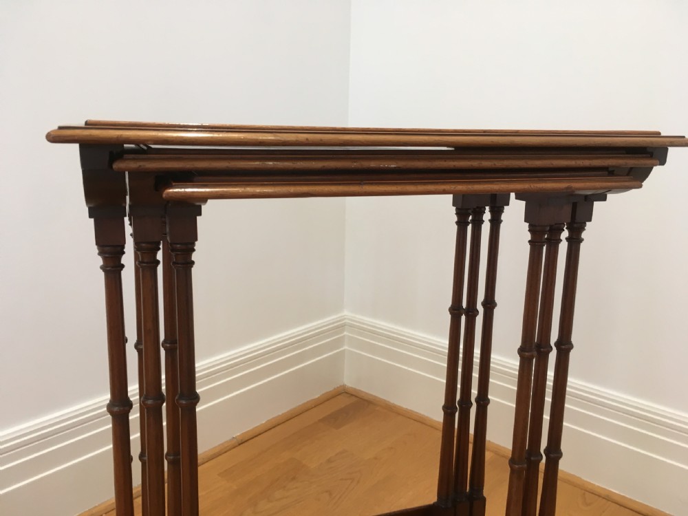 A set of three nested wooden side tables featuring rectangular tops with oval amboyna wood centres, inlaid satinwood borders, and slender turned legs. View XII