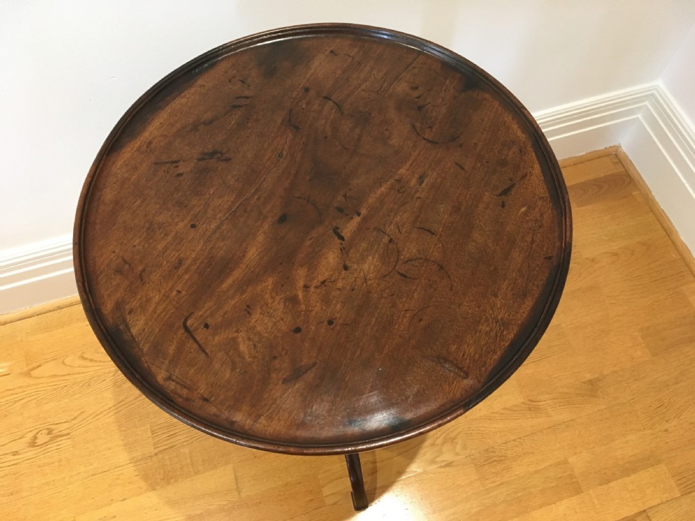 A Georgian dark mahogany tilt-top occasional table featuring a circular dished top supported by a turned central pedestal column and a tripod base with downswept legs. View IV