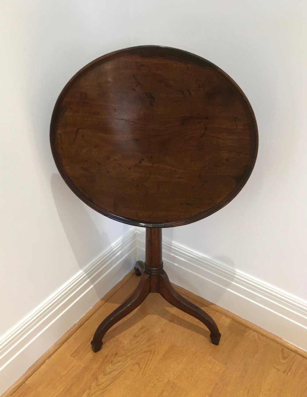 A Georgian dark mahogany tilt-top occasional table featuring a circular dished top supported by a turned central pedestal column and a tripod base with downswept legs. View XIII