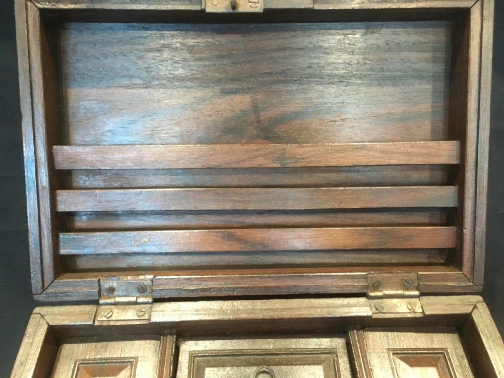 A rectangular warm brown oak desk box featuring brass bound corners, metal straps, a central brass oval cartouche, and a front keyhole escutcheon. View IV