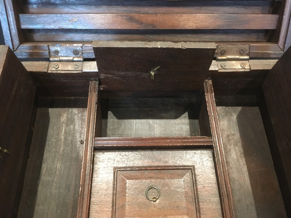 A rectangular warm brown oak desk box featuring brass bound corners, metal straps, a central brass oval cartouche, and a front keyhole escutcheon. View VII