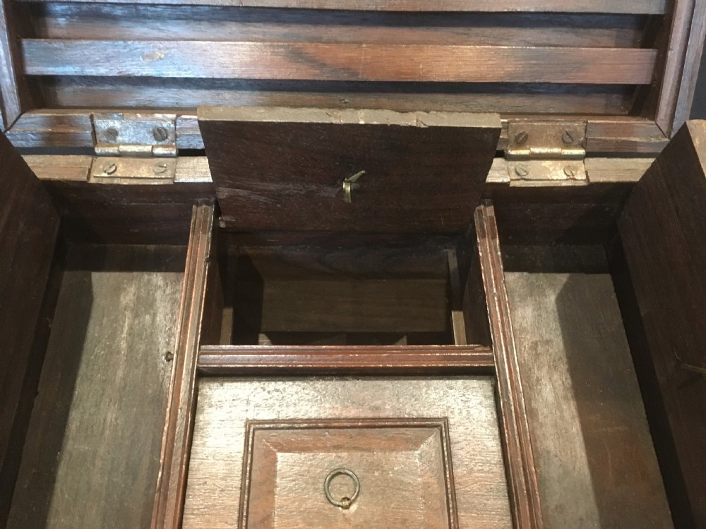 A rectangular warm brown oak desk box featuring brass bound corners, metal straps, a central brass oval cartouche, and a front keyhole escutcheon. View VIII