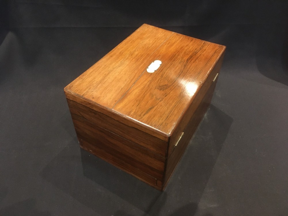 An open rosewood vanity box lined with vibrant blue velvet, containing cut glass jars, silver-plated lids, and manicure tools. View XII