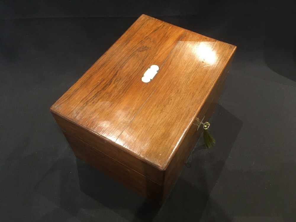 An open rosewood vanity box lined with vibrant blue velvet, containing cut glass jars, silver-plated lids, and manicure tools. View XV