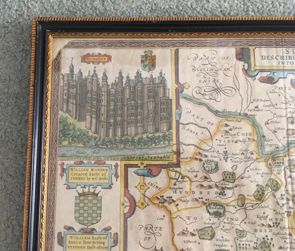 A framed historical map of Surrey by John Speed, displaying administrative divisions, coats of arms, and detailed corner insets of Richmond and Nonsuch palaces. View II