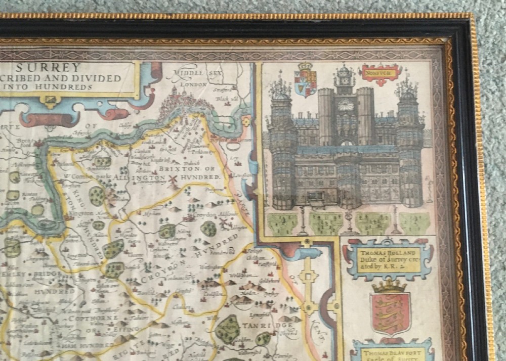 A framed historical map of Surrey by John Speed, displaying administrative divisions, coats of arms, and detailed corner insets of Richmond and Nonsuch palaces. View III