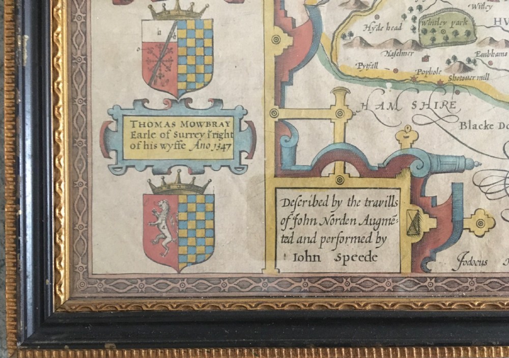 A framed historical map of Surrey by John Speed, displaying administrative divisions, coats of arms, and detailed corner insets of Richmond and Nonsuch palaces. View VI