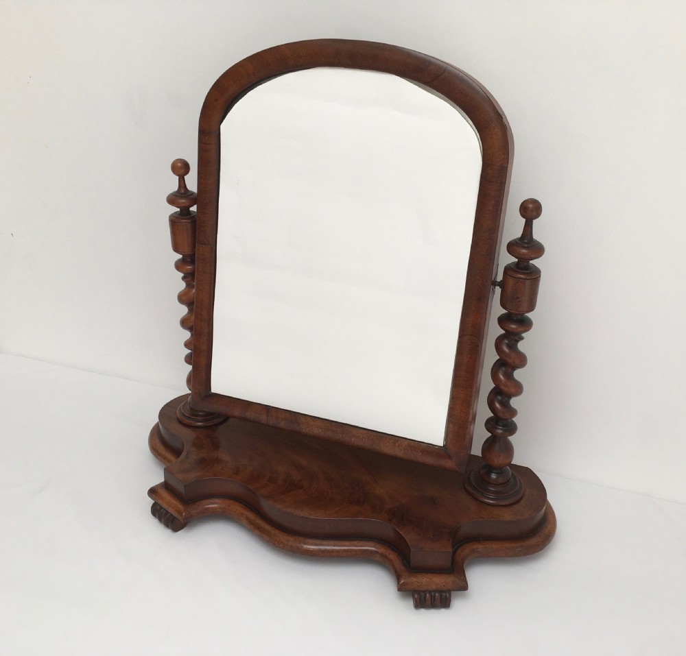 A Victorian mahogany dressing table mirror featuring an arched frame, spiral barley twist uprights, and a shaped plinth base with carved feet. View II