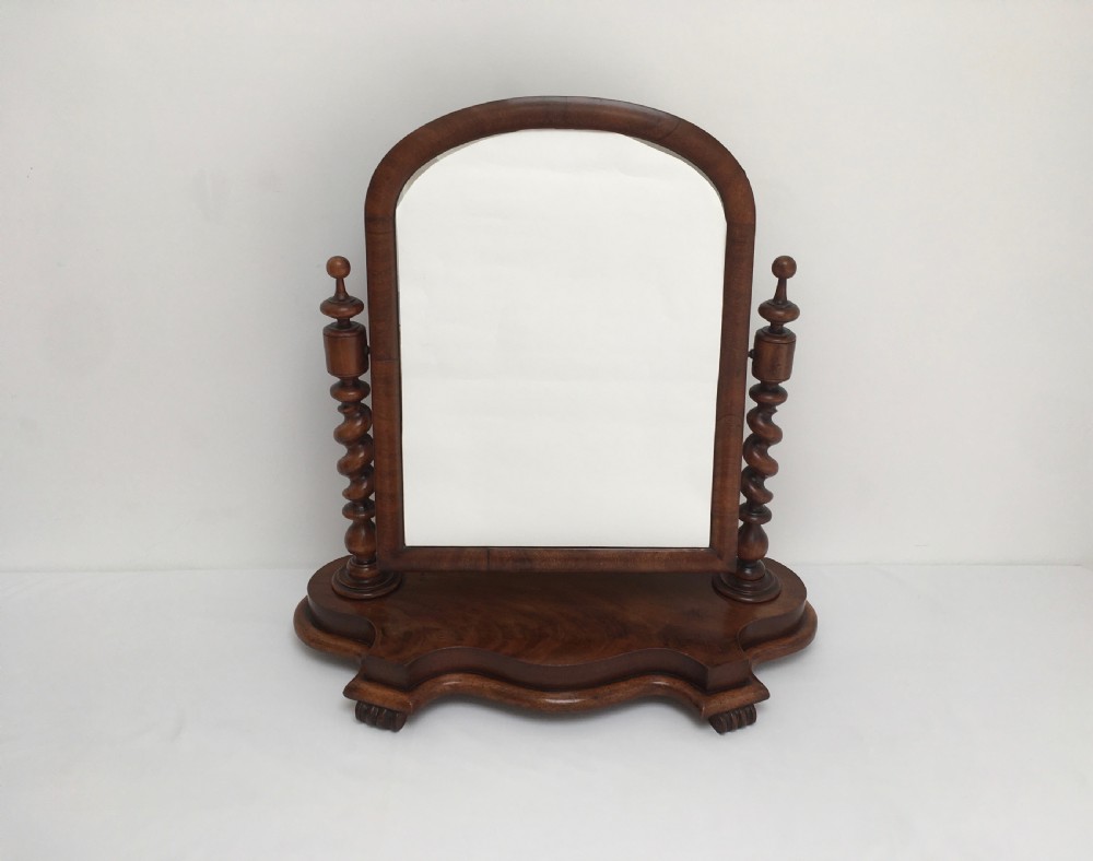 A Victorian mahogany dressing table mirror featuring an arched frame, spiral barley twist uprights, and a shaped plinth base with carved feet. View III