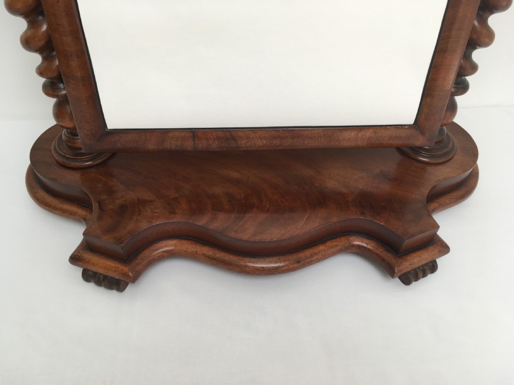 A Victorian mahogany dressing table mirror featuring an arched frame, spiral barley twist uprights, and a shaped plinth base with carved feet. View VI