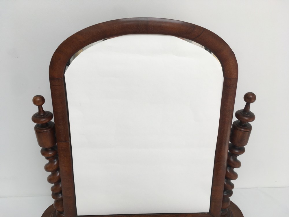 A Victorian mahogany dressing table mirror featuring an arched frame, spiral barley twist uprights, and a shaped plinth base with carved feet. View VII