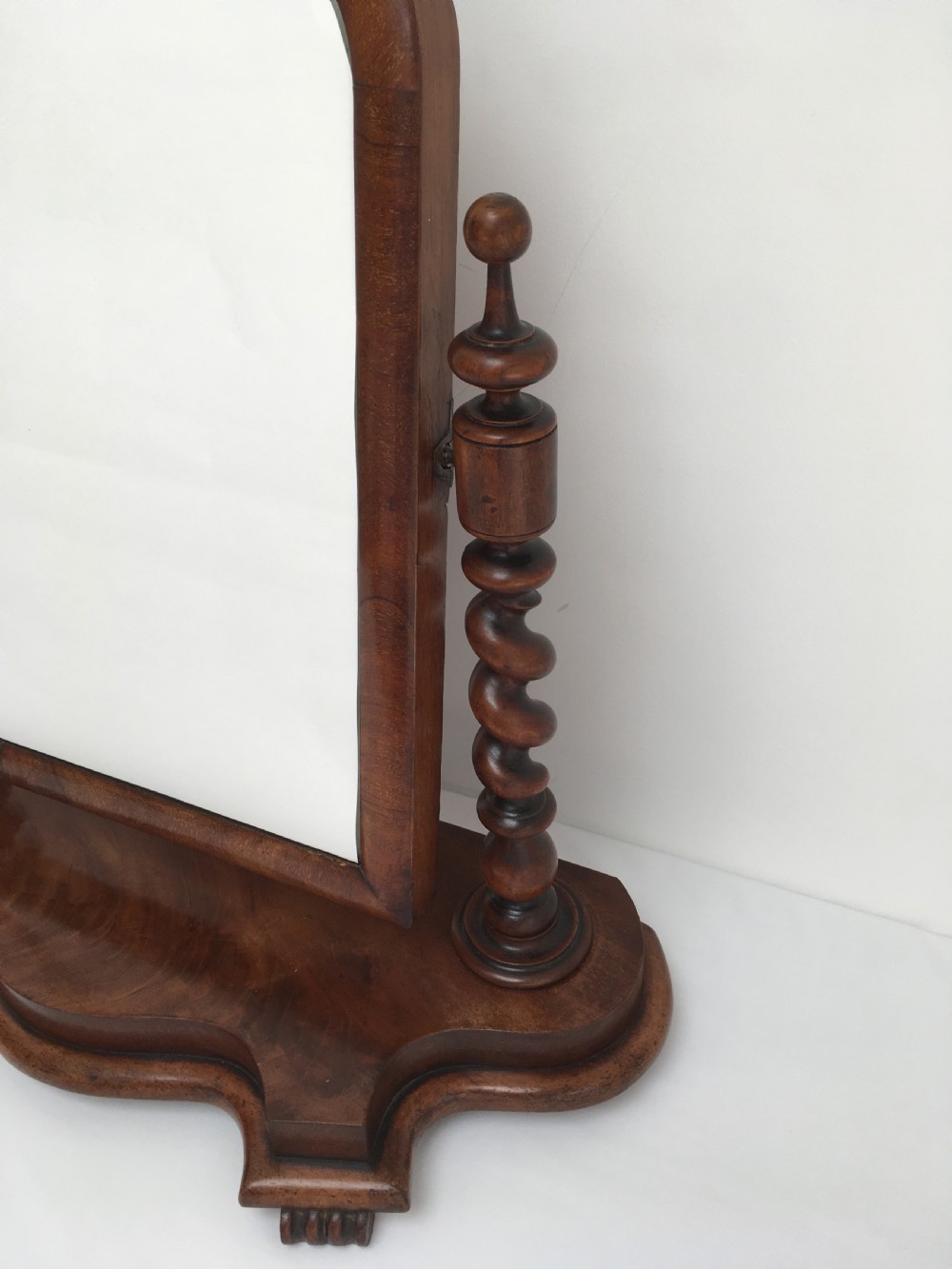 A Victorian mahogany dressing table mirror featuring an arched frame, spiral barley twist uprights, and a shaped plinth base with carved feet. View VIII