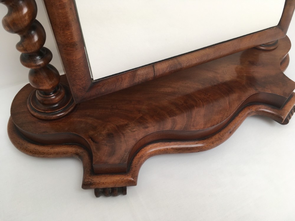 A Victorian mahogany dressing table mirror featuring an arched frame, spiral barley twist uprights, and a shaped plinth base with carved feet. View X