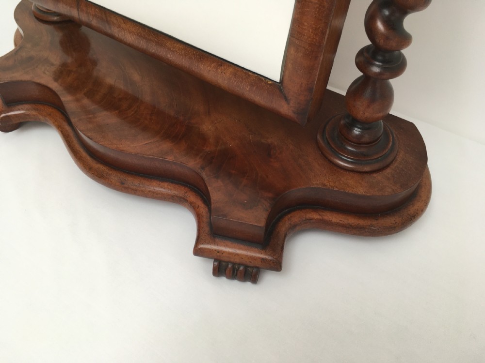 A Victorian mahogany dressing table mirror featuring an arched frame, spiral barley twist uprights, and a shaped plinth base with carved feet. View XI