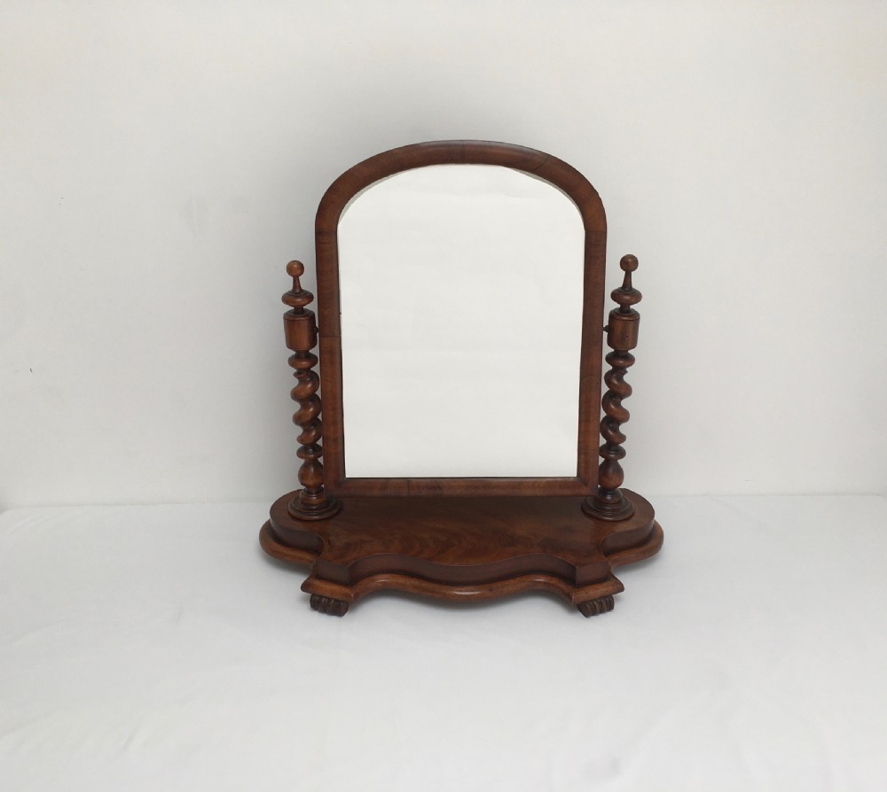 A Victorian mahogany dressing table mirror featuring an arched frame, spiral barley twist uprights, and a shaped plinth base with carved feet. View XII