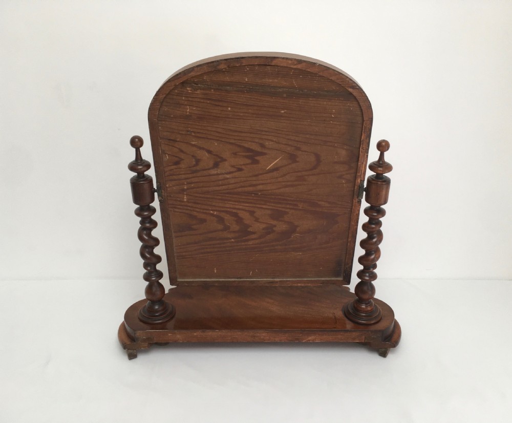 A Victorian mahogany dressing table mirror featuring an arched frame, spiral barley twist uprights, and a shaped plinth base with carved feet. View XIII