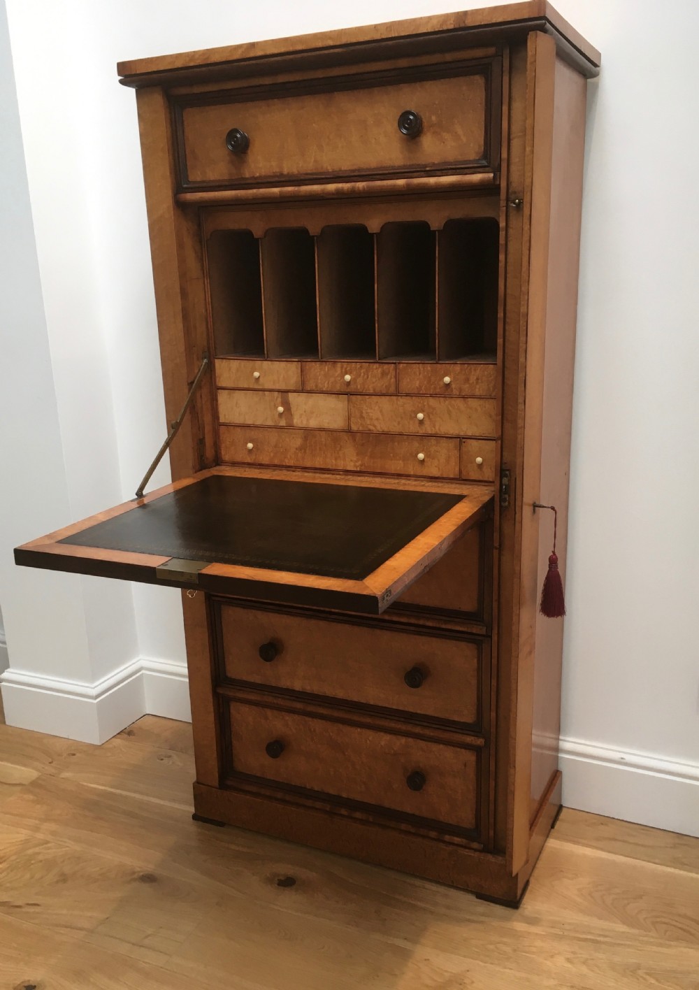 A tall Victorian birdseye maple secretaire Wellington chest featuring a hinged side locking bar, rosewood crossbanding, and a drop-down writing drawer revealing internal compartments. View II