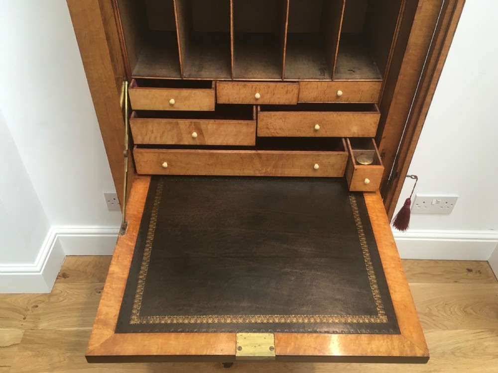 A tall Victorian birdseye maple secretaire Wellington chest featuring a hinged side locking bar, rosewood crossbanding, and a drop-down writing drawer revealing internal compartments. View III