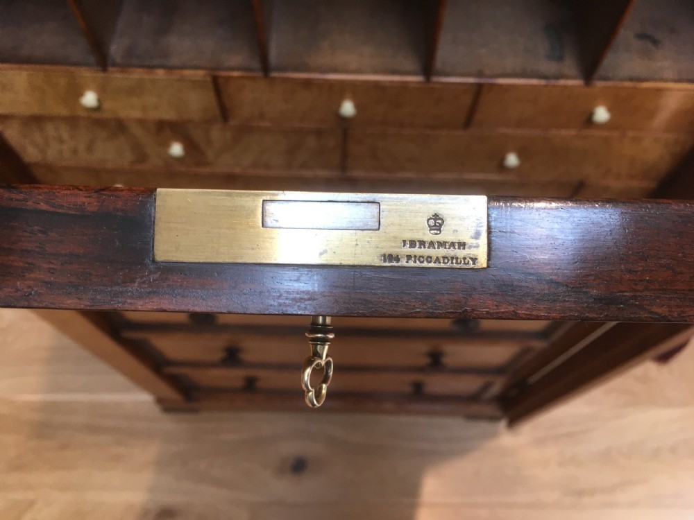 A tall Victorian birdseye maple secretaire Wellington chest featuring a hinged side locking bar, rosewood crossbanding, and a drop-down writing drawer revealing internal compartments. View VII