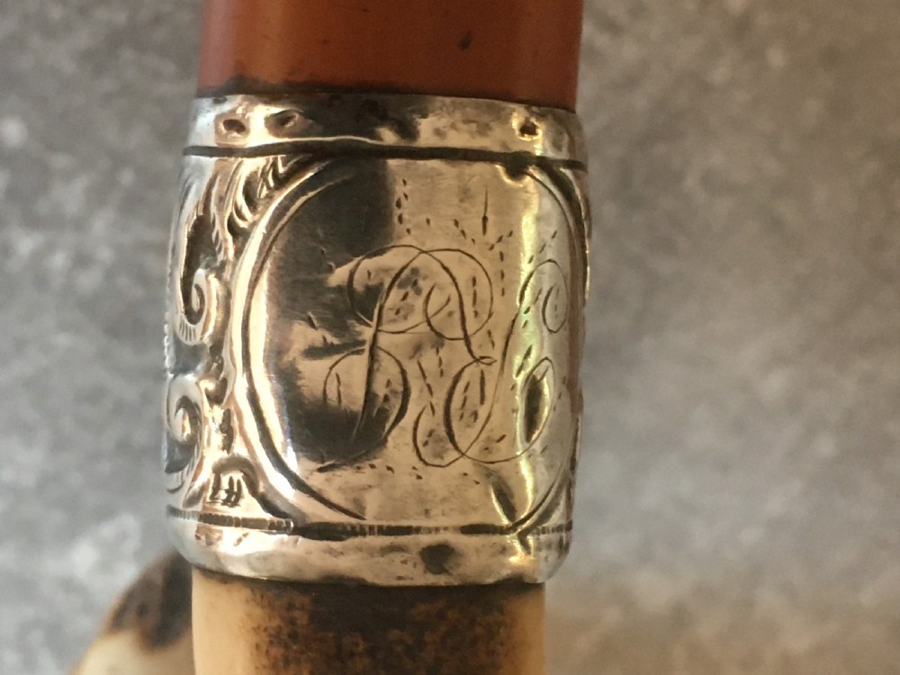 An antique Malacca wood walking stick featuring a carved stag antler handle and silver collar, drawn to reveal a long steel concealed blade. View IV