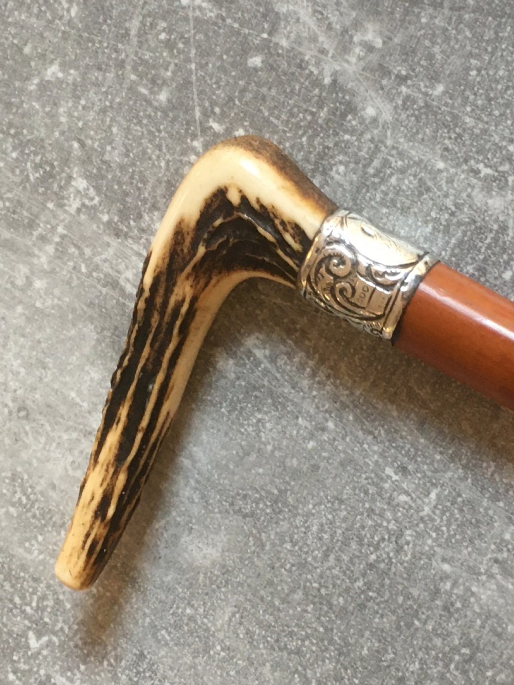 An antique Malacca wood walking stick featuring a carved stag antler handle and silver collar, drawn to reveal a long steel concealed blade. View X