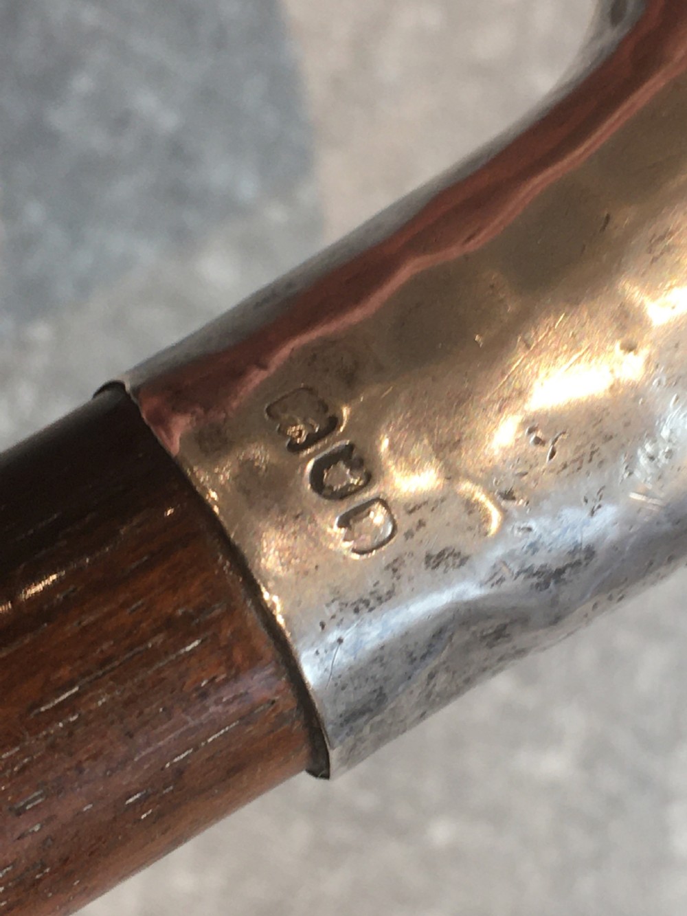 An antique walking stick featuring a hand-hammered silver L-shaped handle fitted to a tapered dark brown wooden shaft. View IV