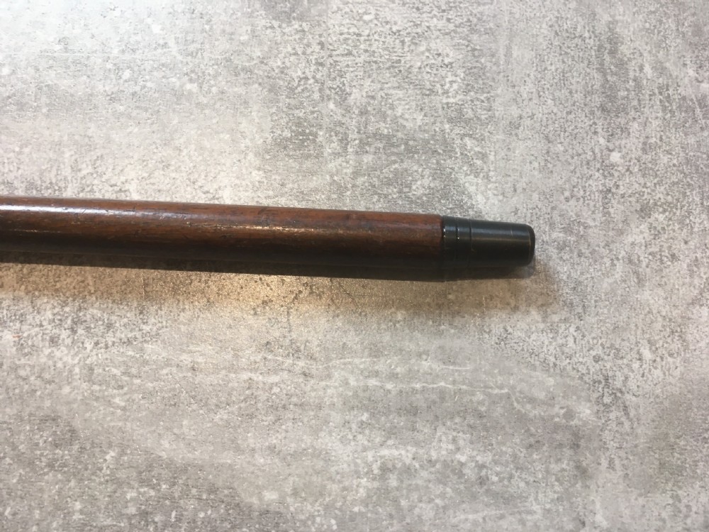 An antique walking stick featuring a hand-hammered silver L-shaped handle fitted to a tapered dark brown wooden shaft. View V