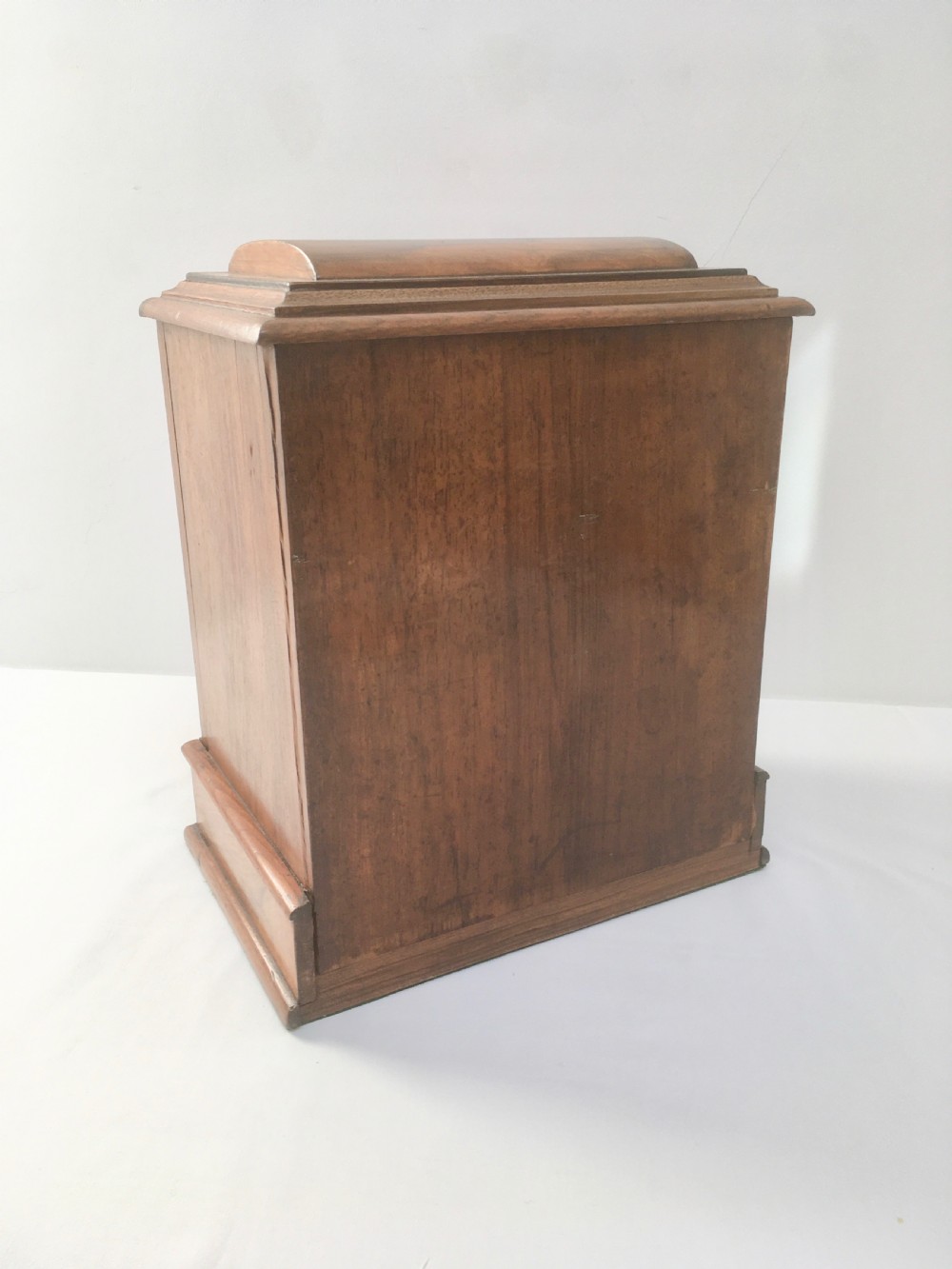An inlaid walnut correspondence chest featuring geometric band inlay around figured wood panels, a domed lid, two front doors, and a central keyhole with a key inserted. View IX