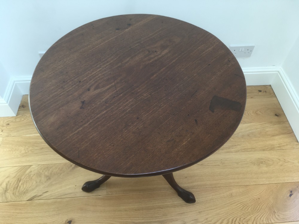 A Georgian mahogany tilt top table featuring a circular top, turned central pedestal, and tripod cabriole legs. View III