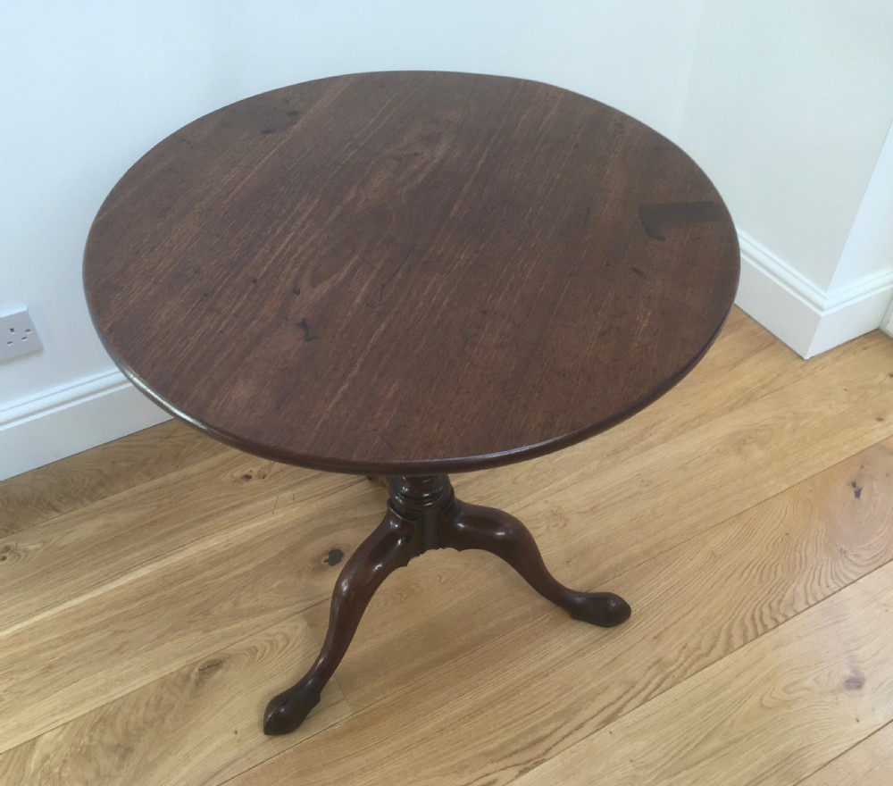 A Georgian mahogany tilt top table featuring a circular top, turned central pedestal, and tripod cabriole legs. View IV